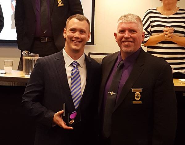 <p>President McFarland presenting the Purple Heart Award to Davenport Officer Ryan Leabo</p>